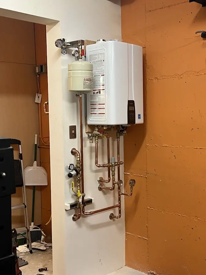 Plumbing technician inspecting water heater connections in Wheatland